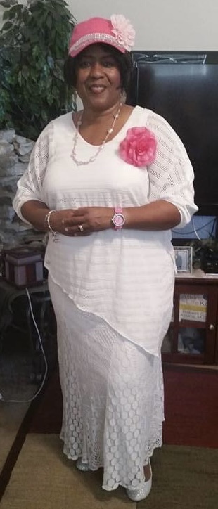 Norma Wilson is pictured standing in a long white dress with pink corsage and hat